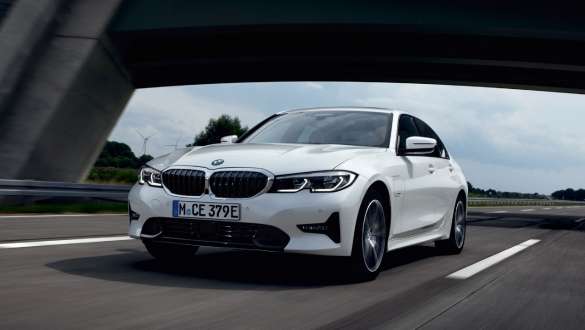 Plug-in hybrid, BMW 3-sarjan Sedan 2021 G20, kolmen neljäsosan näkymä liikkeellä olevan auton keulasta Plug-in hybrid, BMW 3-sarjan Sedan 2021 G20, kolmen neljäsosan näkymä tiellä liikkeellä olevan auton keulasta
