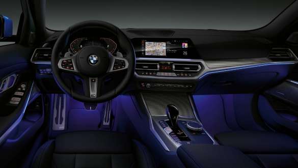 BMW 3-sarjan Sedan, Ambient-tunnelmavalaistus. Kuva BMW 3-sarjan Sedanin sisätilasta kuljettajan puolelta, jalkatilassa sininen valo Ambient-tunnelmavalaistuksella.