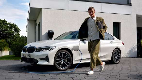 Plug-in Hybrid, BMW 3-sarjan Sedan 2021 G20, kolmen neljäsosan näkymä latauksessa olevan auton keulasta Plug-in Hybrid, BMW 3-sarjan Sedan 2021 G20, kolmen neljäsosan näkymä latauksessa olevan auton keulasta yhdessä mallin kanssa