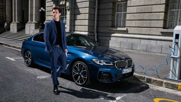 BMW 5-sarjan Sedan Plug-in Hybrid 2021 G30, kolmen neljäsosan näkymä latauksessa olevan auton keulasta BMW 5-sarjan Sedan Plug-in Hybrid 2021 G30, kolmen neljäsosan näkymä latauksessa olevan auton keulasta ja malli