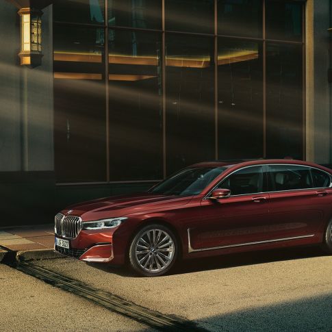 BMW Individual 7-sarjan Sedan, näkymä sivulta Punainen BMW Individual 7-sarjan Sedan sivulta kuvattuna kaupunkimaisemassa