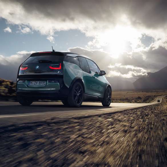 BMW i3 2018, kolmen neljäsosan näkymä auton perästä ajaen maantiellä BMW i3 I01 2018 Jucaro Beige, korostuksella Frozen Grey -metalliväri, kolmen neljäsosan näkymä auton perästä ajaen maantiellä