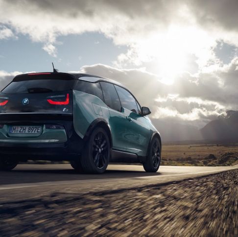 BMW i3 2018, 3/4-näkymä takaa ajaen maantiellä BMW i3 I01 2018 Jucaro Beige, korostuksella Frozen Grey -metalliväri, kolmen neljäsosan näkymä auton perästä ajaen maantiellä