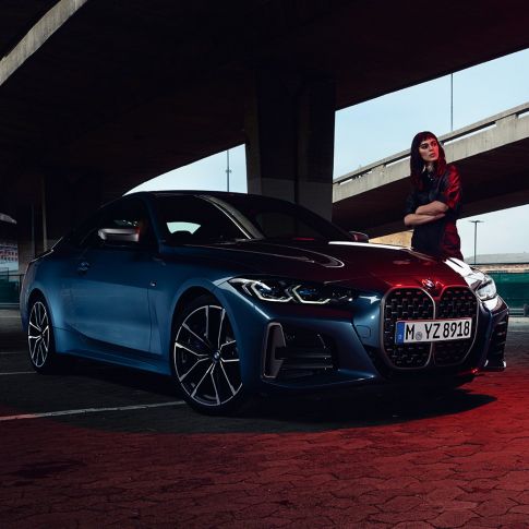 Malli seisoo BMW M440i xDrive Coupé G22 2020 -auton vieressä, kolmen neljäsosan sivunäkymä BMW M440i xDrive Coupé metalliväri Arctic Race Blue G22 2020, kuvassa kolmen neljäsosan sivunäkymä ja malli