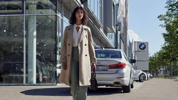 Nainen BMW-liikkeen edessä BMW Huolenpitosopimus nainen BMW-liikkeen edessä