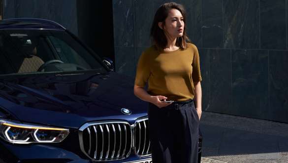 Nainen BMW:n edessä BMW Liikkuvuuspalvelu nainen BMW-auton edessä