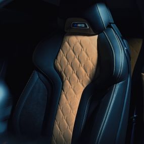 BMW M8 Competition Coupé, M urheiluistuin. BMW M8 Competition Coupé, M urheiluistuin, jossa M8-merkki ja musta Merino-täysnahkaverhoilu, jossa kontrastivärinä Midrand Beige.