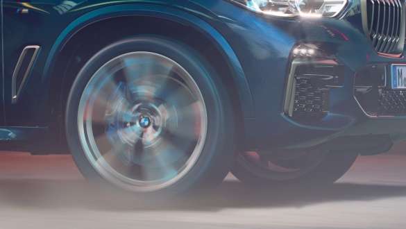 BMW X5 M50i ja M50d, jossa adaptiivinen M-alusta BMW X5 M50i ja M50d, joissa adaptiivinen M-alusta, Carbon Black -metalliväri F95, lähikuva vanteesta