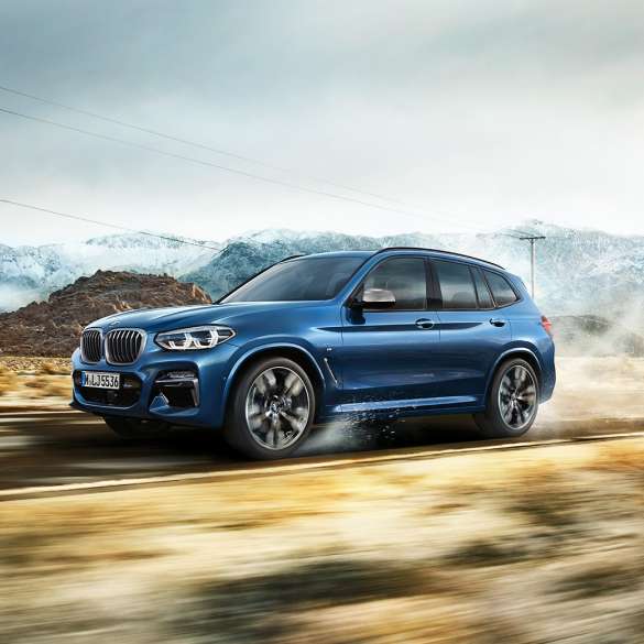 BMW X3 M40i, kokokuva vanteesta ja lokasuojasta vuoriston edessä BMW X3 M40i, kokokuva vanteesta ja lokasuojasta vuoriston edessä
