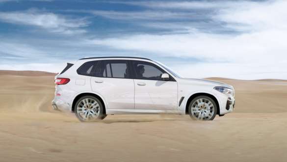 Ajotila xSand, BMW X5 Ajotila xSand, BMW X5 G05 2018 metalliväri Mineral White, sivunäkymä hiekalla ajavasta autosta