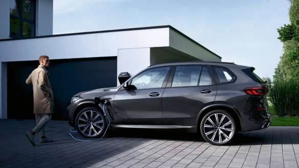 Plug-in hybrid BMW X5 xDrive45e G05, sivunäkymä autotallin edessä Plug-in hybrid BMW X5 xDrive45e G05, sivunäkymä autotallin edessä yhdessä mallin kanssa