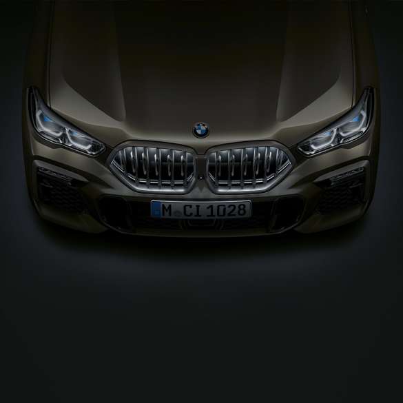 BMW X6, keula. Lintuperspektiivistä otettu lähikuva BMW X6:n keulassa olevasta BMW:n Iconic Glow -jäähdyttimensäleiköstä.