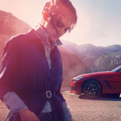 BMW Z4 Roadster vuoristomaisemassa Nainen ja mies BMW Z4 Roadsterin edessä vuoristomaisemassa