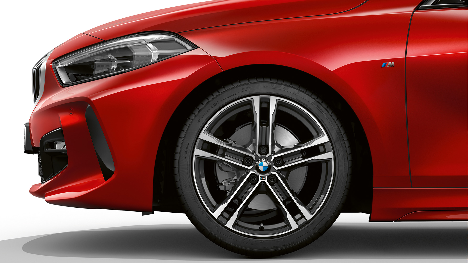 BMW 1-sarja malli M Sport, etuosa sivulta. BMW 1-sarjan malli M Sport, Melbourne Red metalliväri, sivulla edessä 17" M kevytmetallivanne Double-spoke 550 M Bicolor.