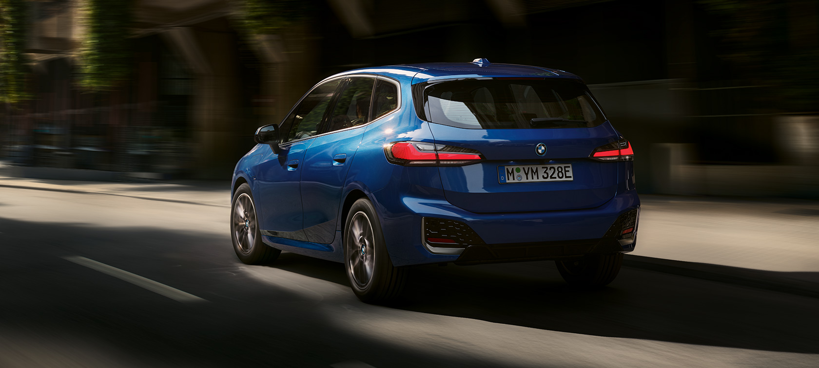 BMW 2-sarjan Active Tourer 230e Plug-in Hybrid U06 2021 metalliväri M Portimao Blue, kolmen neljäsosan näkymä takaa katsottuna kaupunkiajossa
