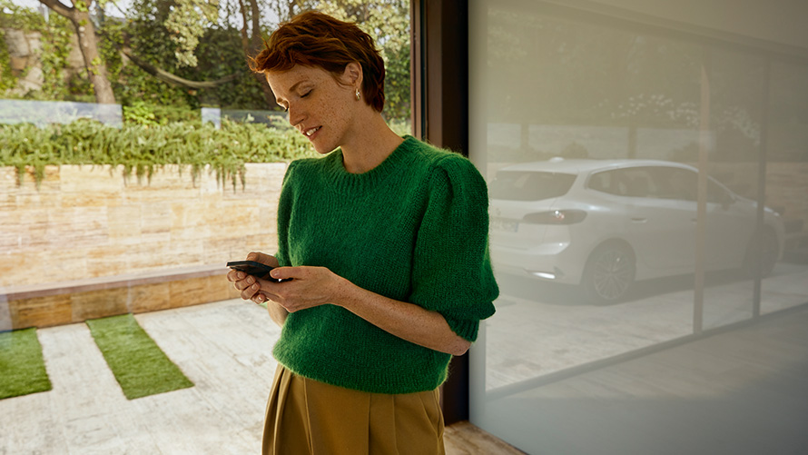 BMW Huolenpitosopimus, naisella kädessä älypuhelin Naisella kädessä älypuhelin, BMW Huolenpitosopimus