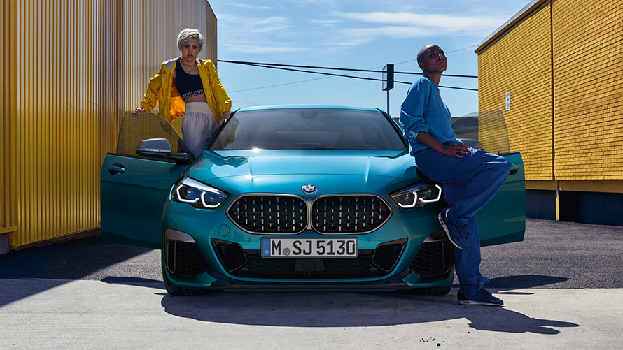 BMW 2-sarjan Gran Coupé F44, näkymä edestä BMW 2-sarjan Gran Coupé F44 metalliväri Snapper Rocks Blue, näkymä edestä autosta, jossa kaksi henkilöä ja ovet avattuina