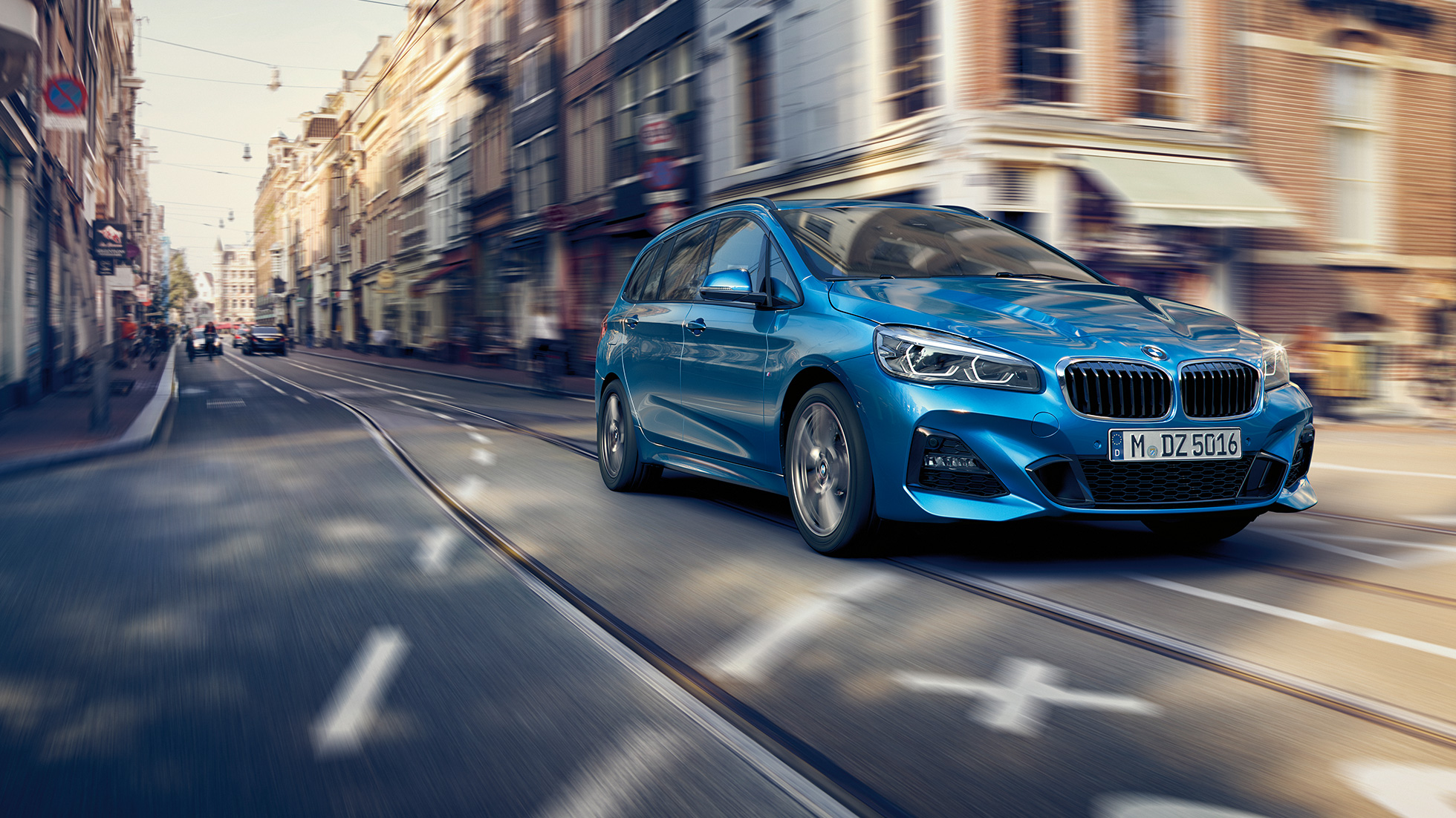 Ajodynamiikka, BMW 2-SARJAN Gran Tourer Ajodynamiikka, BMW 2-SARJAN Gran Tourer F46 2018 metalliväri Estoril Blue, kolmen neljäsosan näkymä kaupungin keskustassa liikkeellä olevan auton keulasta
