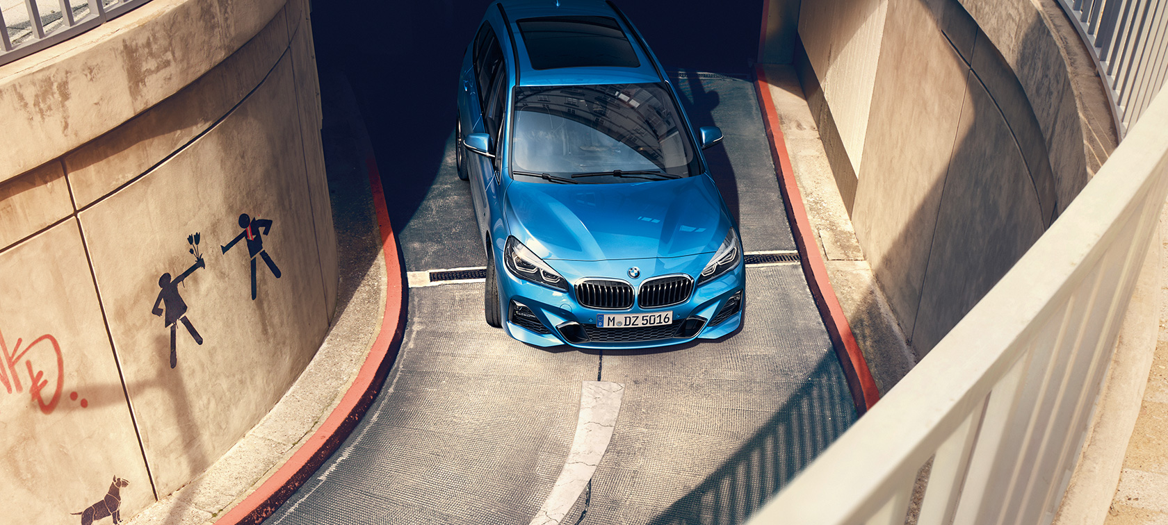 BMW 2-SARJAN Gran Tourer liikkeellä pysäköintitalossa BMW 2-SARJAN Gran Tourer F46 metalliväri Estoril Blue, pysäköintitalossa liikkeellä oleva auto lintuperspektiivistä
