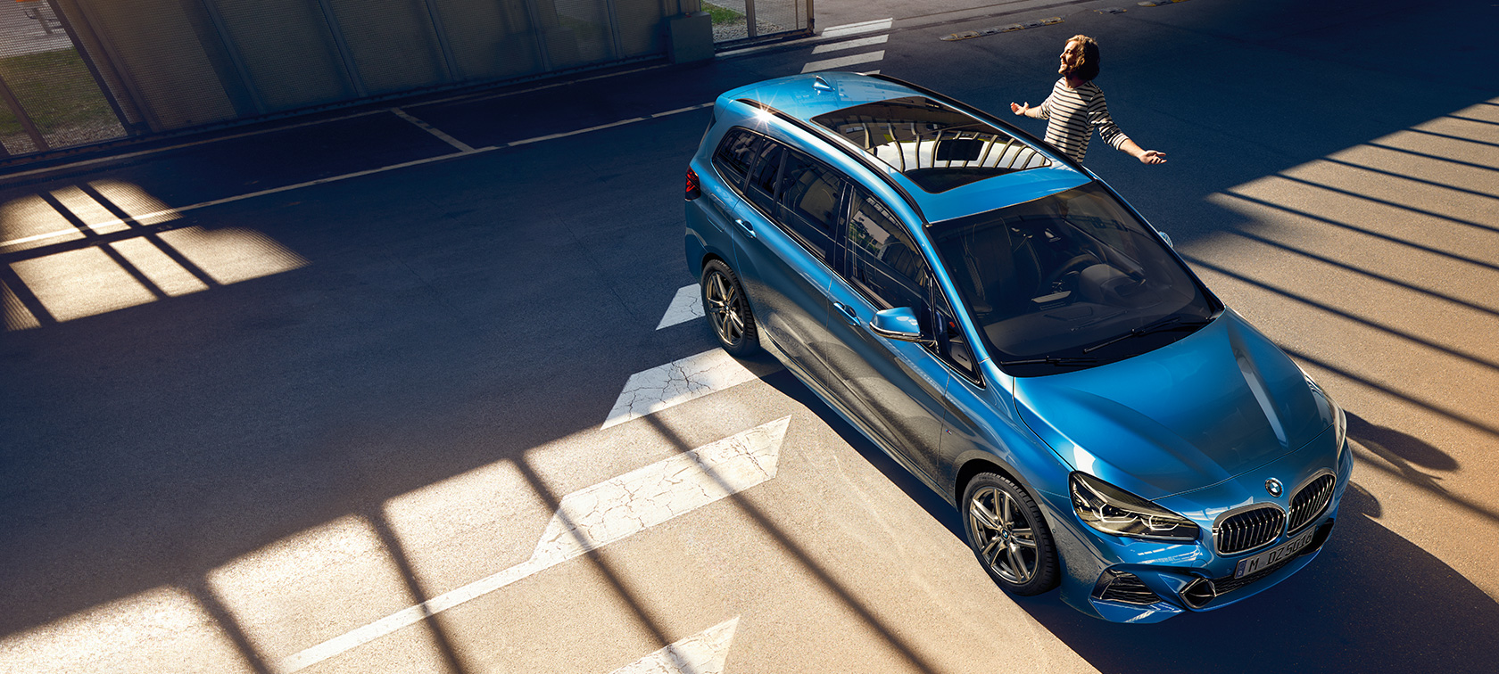 BMW 2-SARJAN Gran Tourer ja perhe Perhe Estoril Blue -metallivärisen BMW 2-SARJAN Gran Tourer F46 Facelift 2018 -auton vieressä