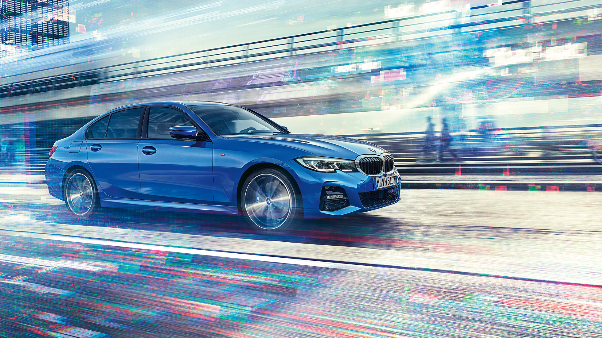 Liikkuva BMW 3-sarjan Sedan sivultapäin. Sivukuva liikkuvasta BMW 3-sarjan Sedanista päivänvalossa suurkaupunkiympäristössä.