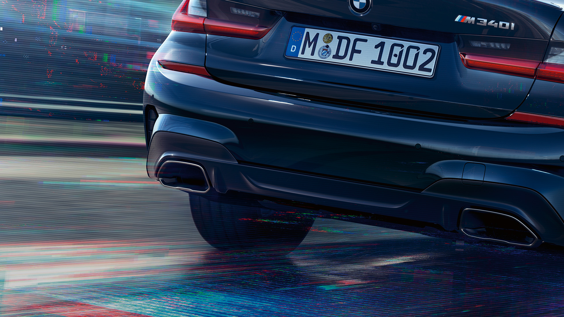 BMW 3-sarjan Sedan, M pakoputkenpäät. Lähikuva takaapäin BMW 3-sarjan Sedanista jossa Cerium Grey -metalliväriset M pakoputkenpäät.