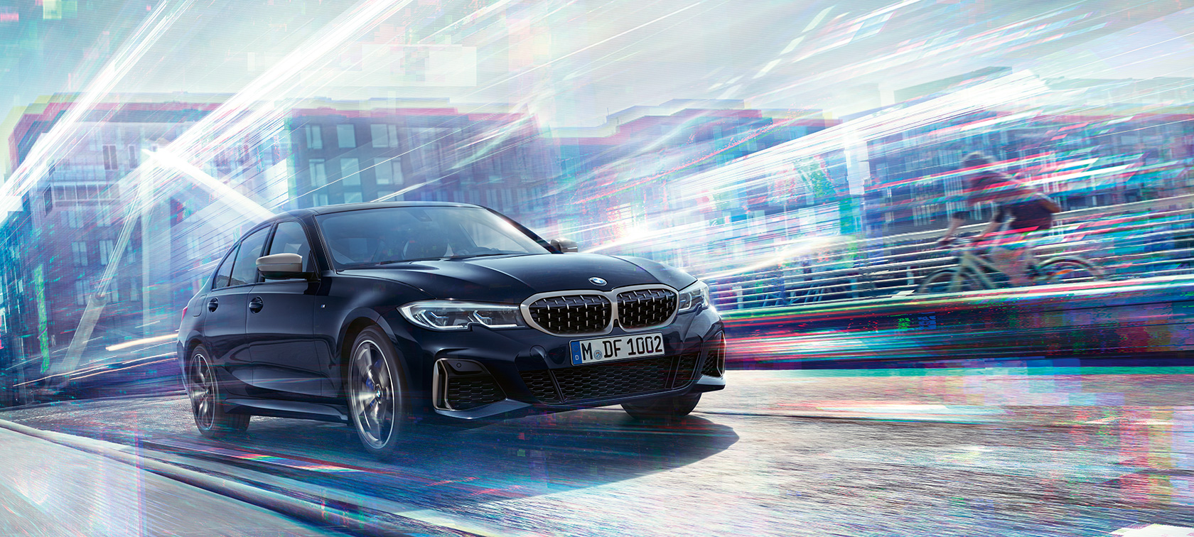BMW 3-sarjan Sedan, BMW M340i xDrive. Kolmeneljäsosa-sivukuva mallista BMW M340i xDrive ajamassa suurkaupungin kadulla.