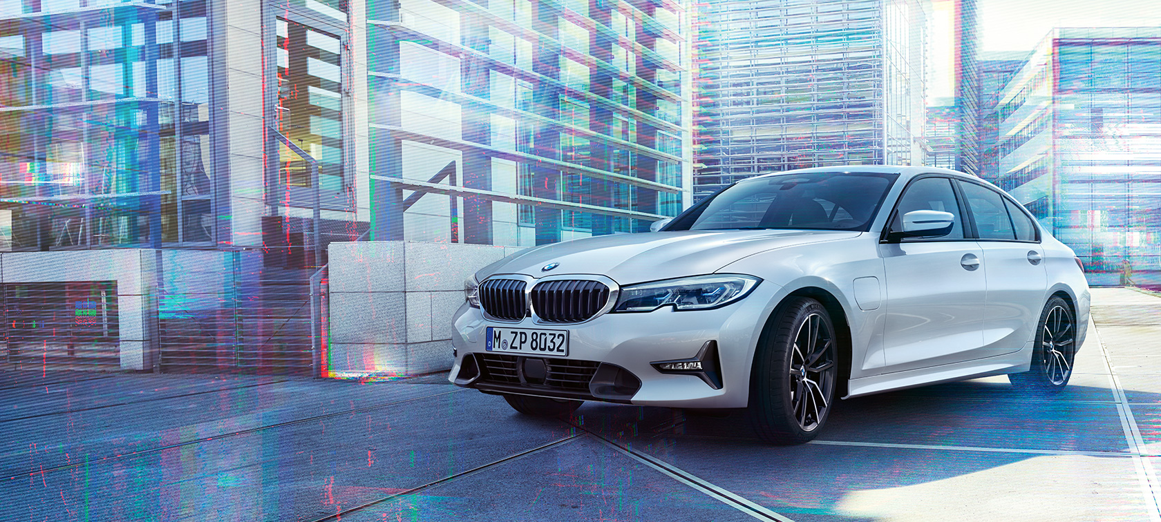BMW 3-sarjan Sedan 330e. Kolmeneljäsosakuva edestäpäin BMW 3-sarjan Sedanin mallista 330e suurkaupunkiympäristössä.