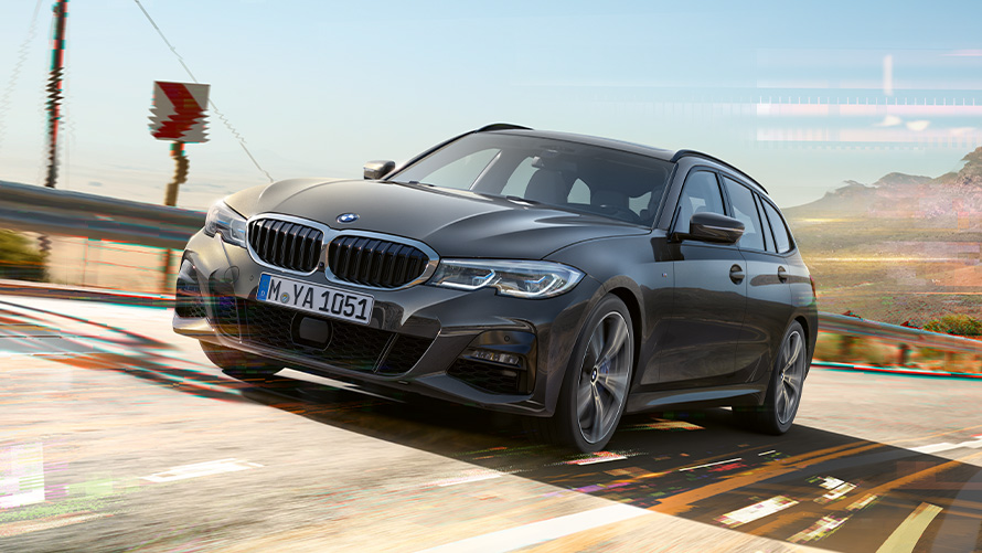 BMW 3-sarjan Touring (G21) Dravite Grey, kolmen neljäsosan näkymä keulasta BMW 3-sarjan Touring (G21) Dravite Grey, kolmen neljäsosan näkymä liikkeellä olevan auton keulasta maaseudulla