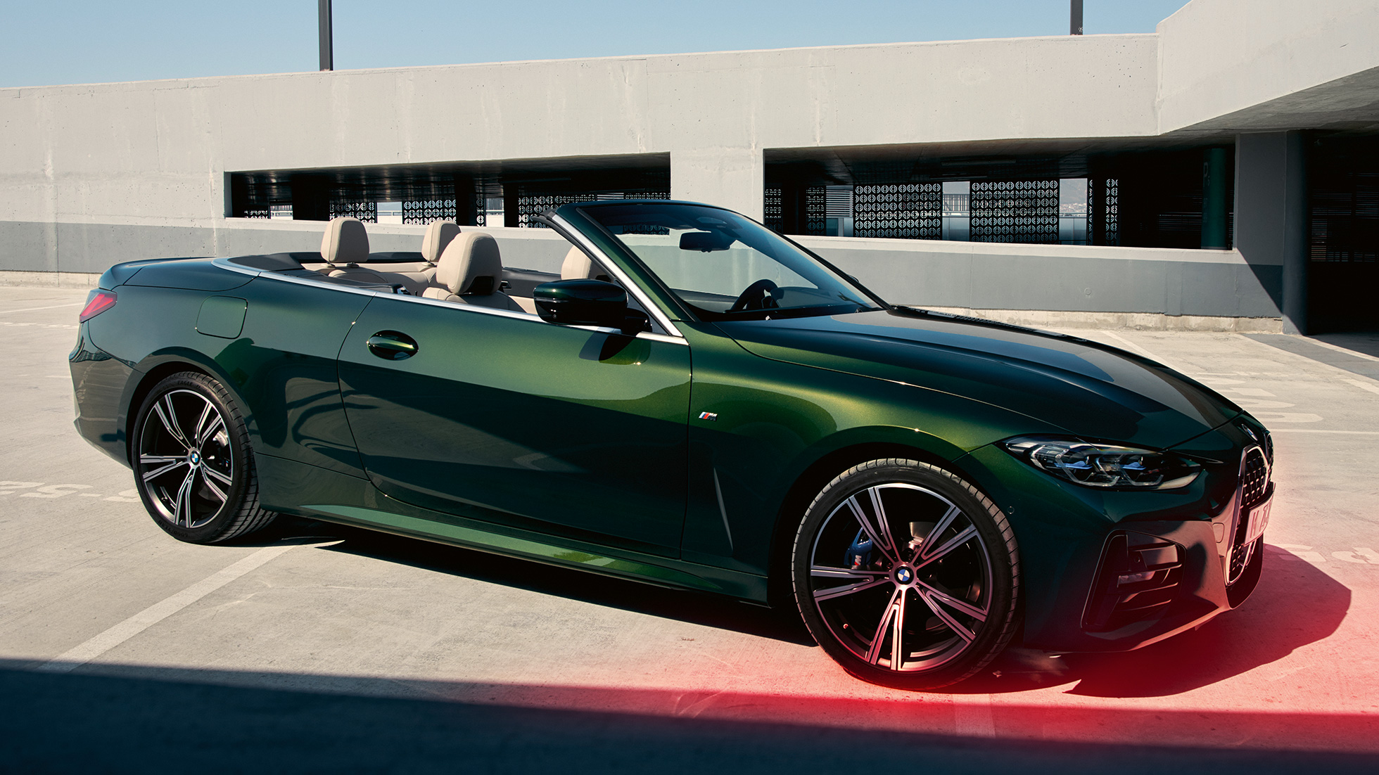 Kolmen neljäsosan näkymä edestä BMW 4-sarjan Cabrio G23 2020 ja mies BMW 4-sarjan Cabrio G23 2020 metalliväri Sanremo Green kolmen neljäsosan näkymä edestä mies vieressä