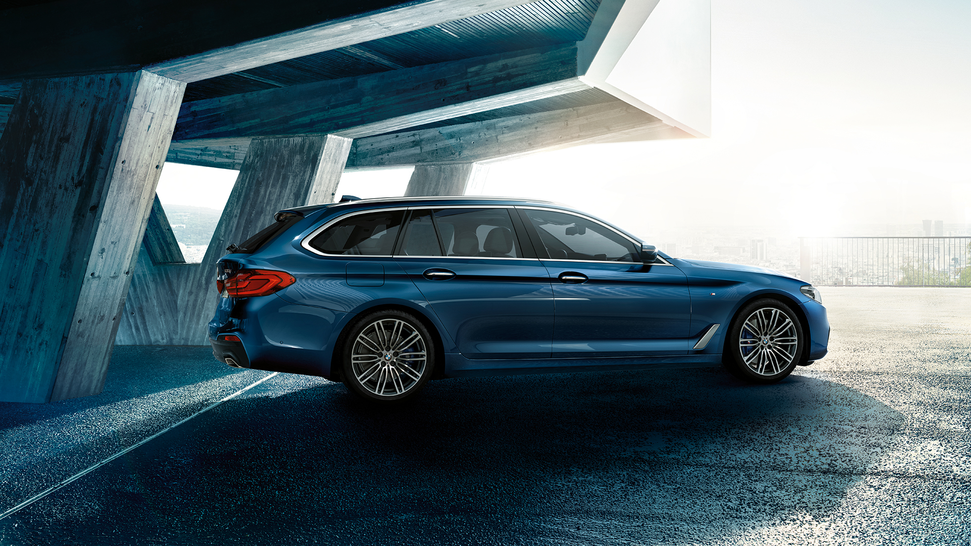 BMW 5-sarjan Touringin sivunäkymä BMW 5-sarjan Touring 530d xDrive Touring G31, metalliväri Mediterranean Blue, kolmen neljäsosan näkymä sivulta