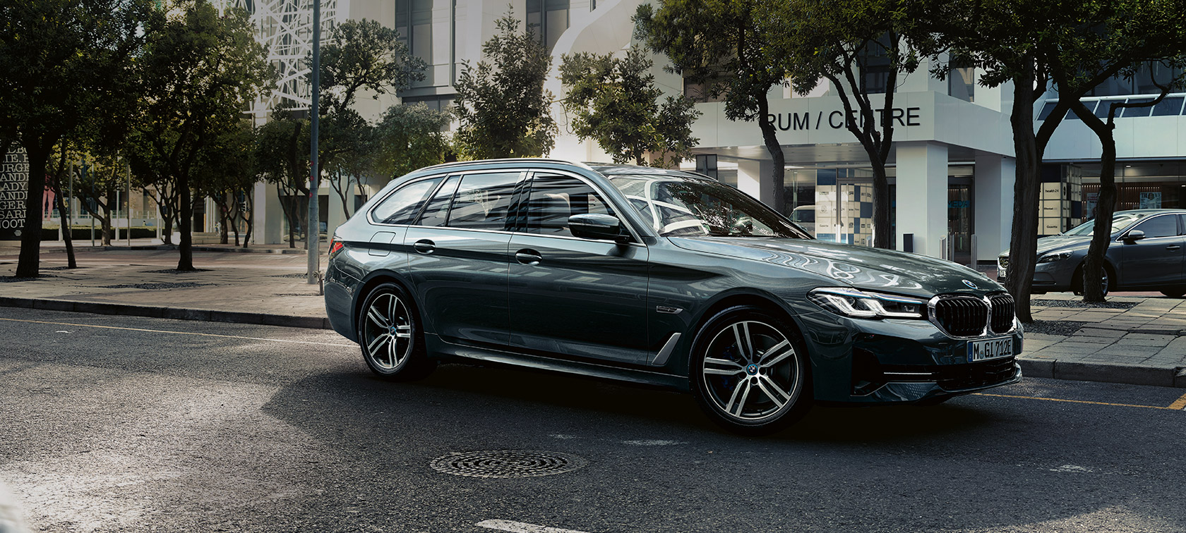 BMW 5-sarjan Touring G31 Facelift 2020 Sophisto Grey, 7/8-näkymä laitakaupungilla ajavan auton keulasta
