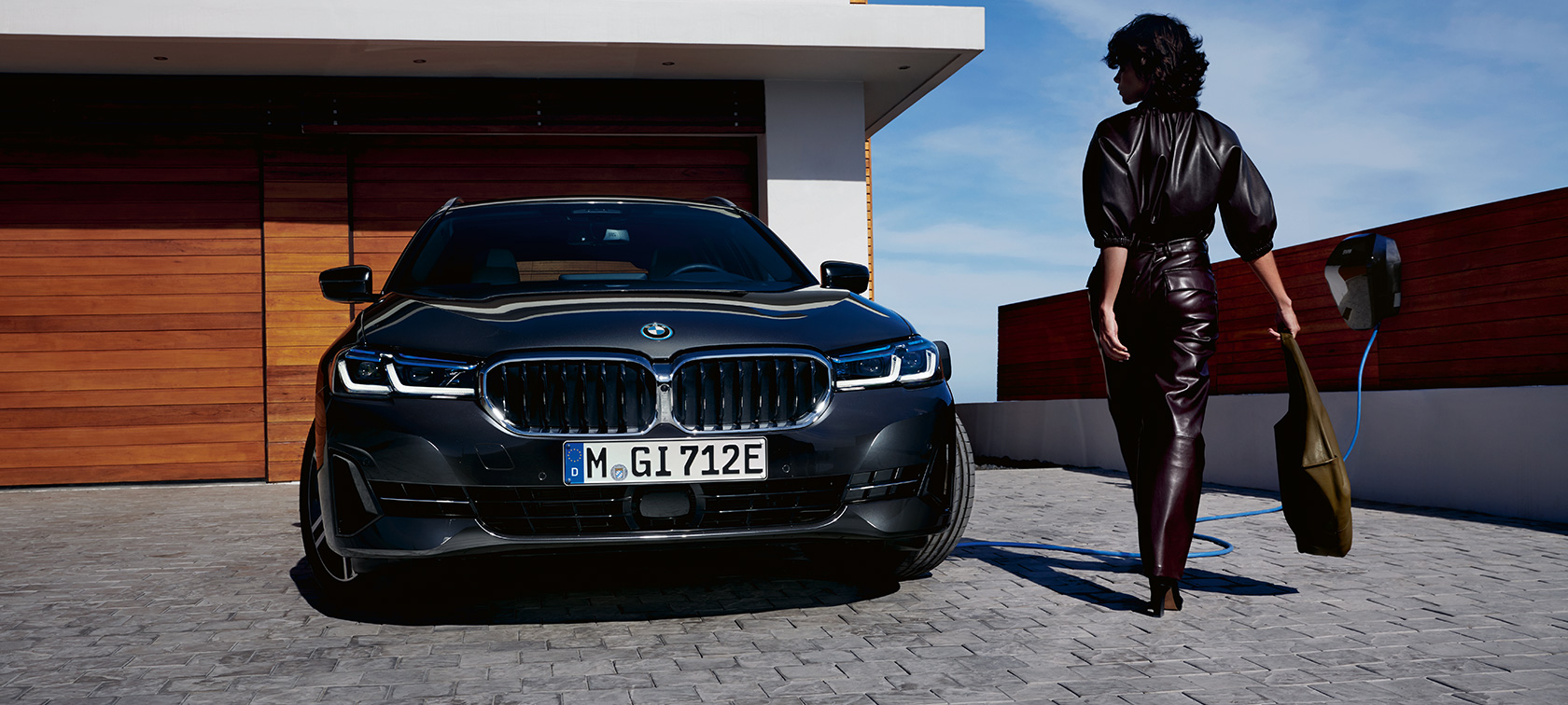 Plug-in Hybrid, BMW 5-sarjan Touring 2021 G31 LCI, näkymä latauksessa olevan auton keulasta Plug-in Hybrid, BMW 5-sarjan Touring 2021 G31 LCI, näkymä latauksessa olevan auton keulasta ja malli