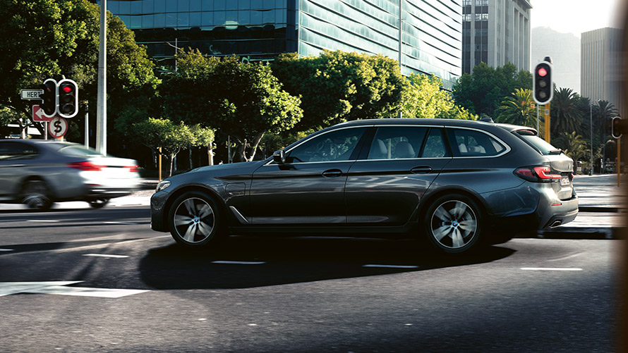 BMW 530e Touring G31 LCI metallivärissä Sophisto Grey ajamassa kaupunkiliikenteessä BMW 530e Touring G31 LCI metallivärissä Sophisto Grey ajamassa kaupunkiliikenteessä
