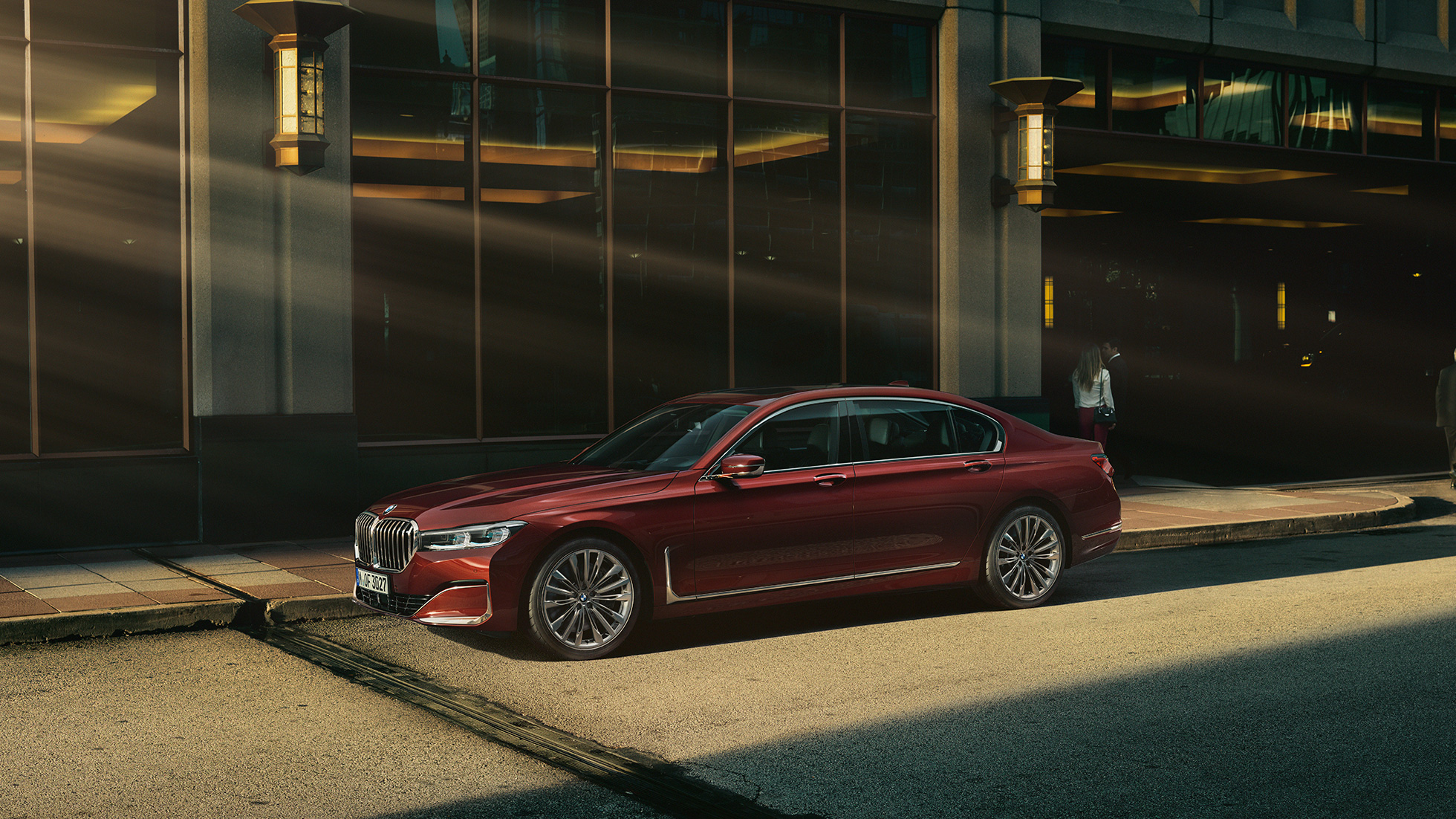 BMW Individual 7-sarjan Sedan, näkymä sivulta Punainen BMW Individual 7-sarjan Sedan sivulta kuvattuna kaupunkimaisemassa