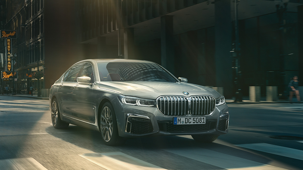 BMW 7-sarjan Sedanin Driving Assistant Professional Driving Assistant Professional: Kuva, jossa näkyy kolme neljäsosaa BMW 7-sarjan Sedanista, joka ajaa kaupunkiympäristössä