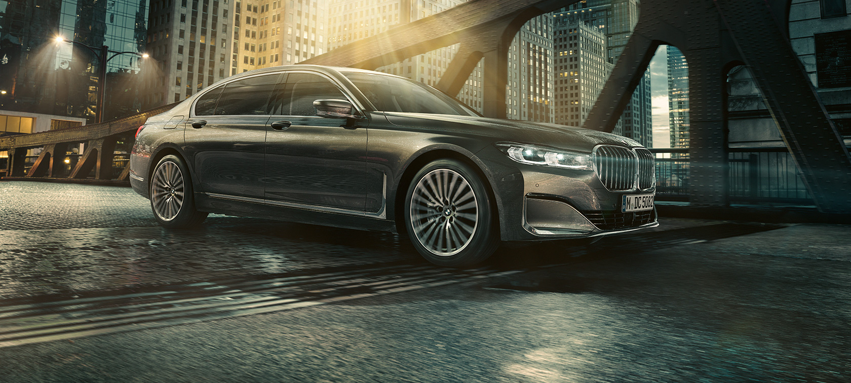 BMW 7-sarjan Sedan, näkymä sivulta BMW 7-sarjan Sedan seisoo sivulta nähtynä, ovi auki valaistun hotellin edessä