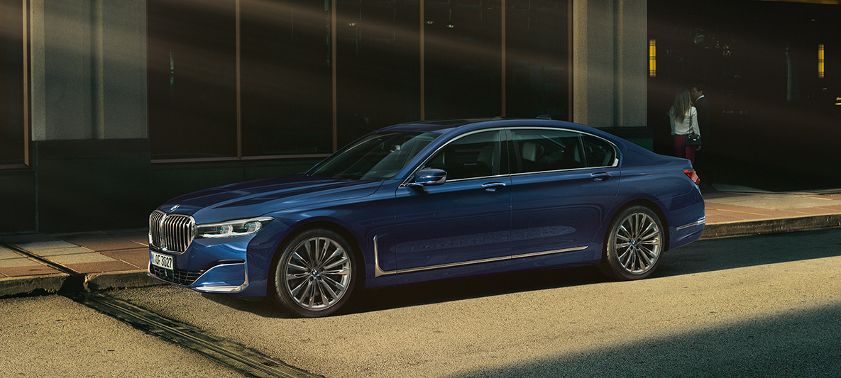 BMW Individual 7-sarjan Sedan, näkymä sivulta Punainen BMW Individual 7-sarjan Sedan sivulta kuvattuna kaupunkimaisemassa