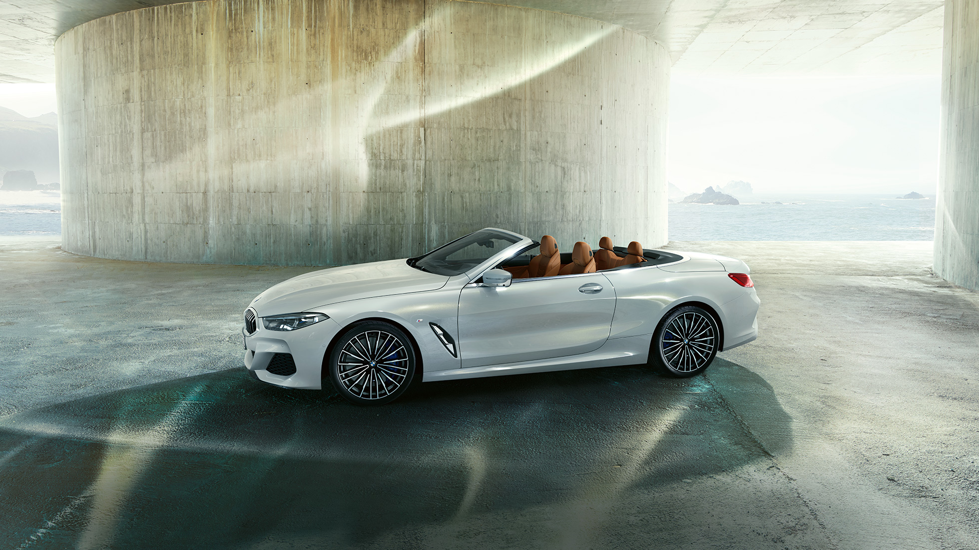 Mineral White -metallivärinen BMW M850i xDrive, sivultapäin kuvattuna kangaskatto auki. Mineral White -metallivärinen BMW M850i xDrive, sivultapäin kuvattuna kangaskatto auki.