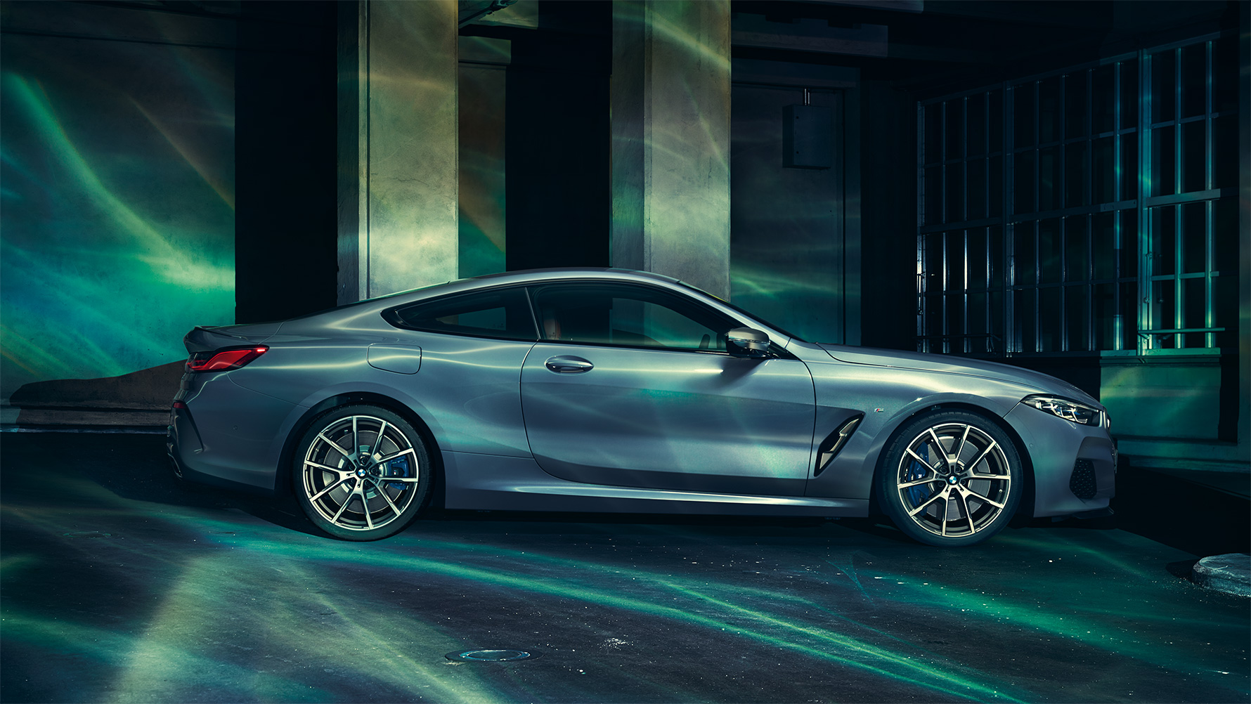 BMW 8-sarja, sivukuva BMW 8-sarjan Coupé sivultapäin suurkaupunkitaustaa vasten.