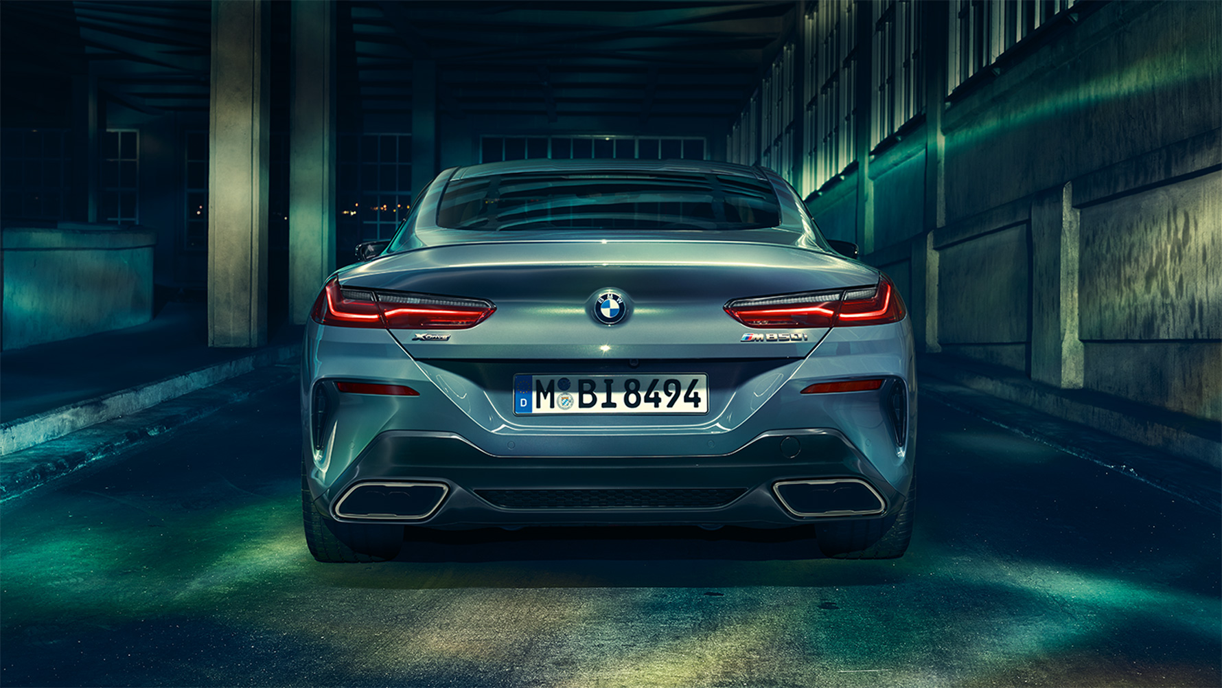 BMW 8-sarjan Coupé, kuva takaapäin BMW 8-sarjan Coupé takaapäin suurkaupungin yössä.