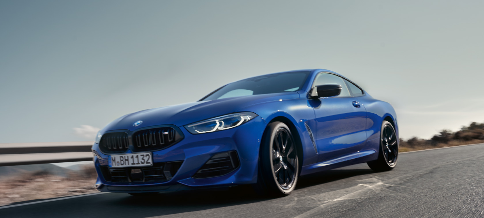 BMW 8-sarjan Coupé G15 mallin uudistus 2022 BMW M850i xDrive metalliväri M Portimao Blue, näkymä liikkeellä olevasta autosta edestä sammakkoperspektiivistä BMW 8-sarjan Coupé G15 mallin uudistus 2022 BMW M850i xDrive metalliväri M Portimao Blue, näkymä liikkeellä olevasta autosta edestä sammakkoperspektiivistä maantiellä kumpuilevassa maastossa