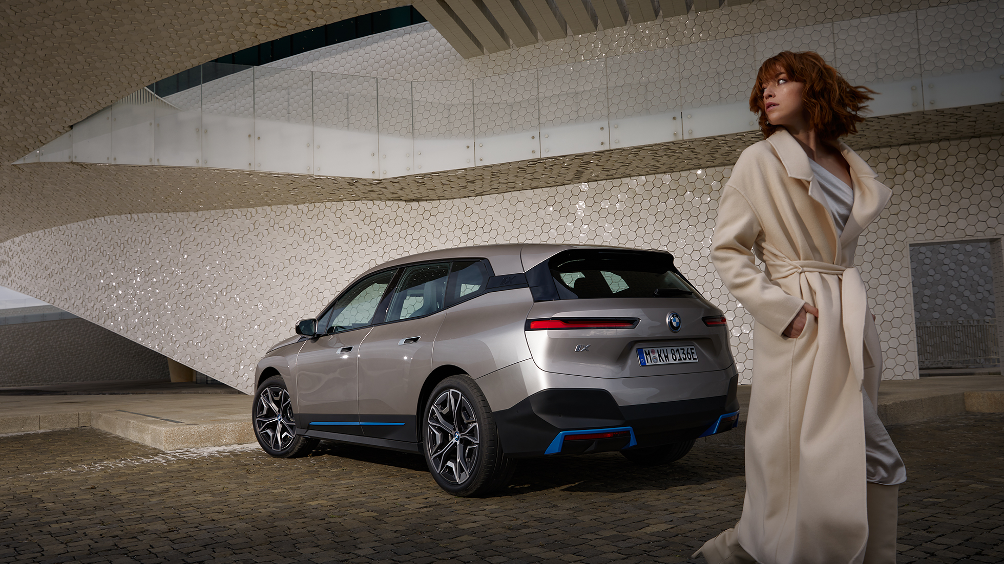 BMW iX, kolmen neljäsosan näkymä pysähtyneenä olevan auton perästä BMW iX i20 Cashmere Silver, kolmen neljäsosan näkymä pysähtyneenä olevan auton perästä