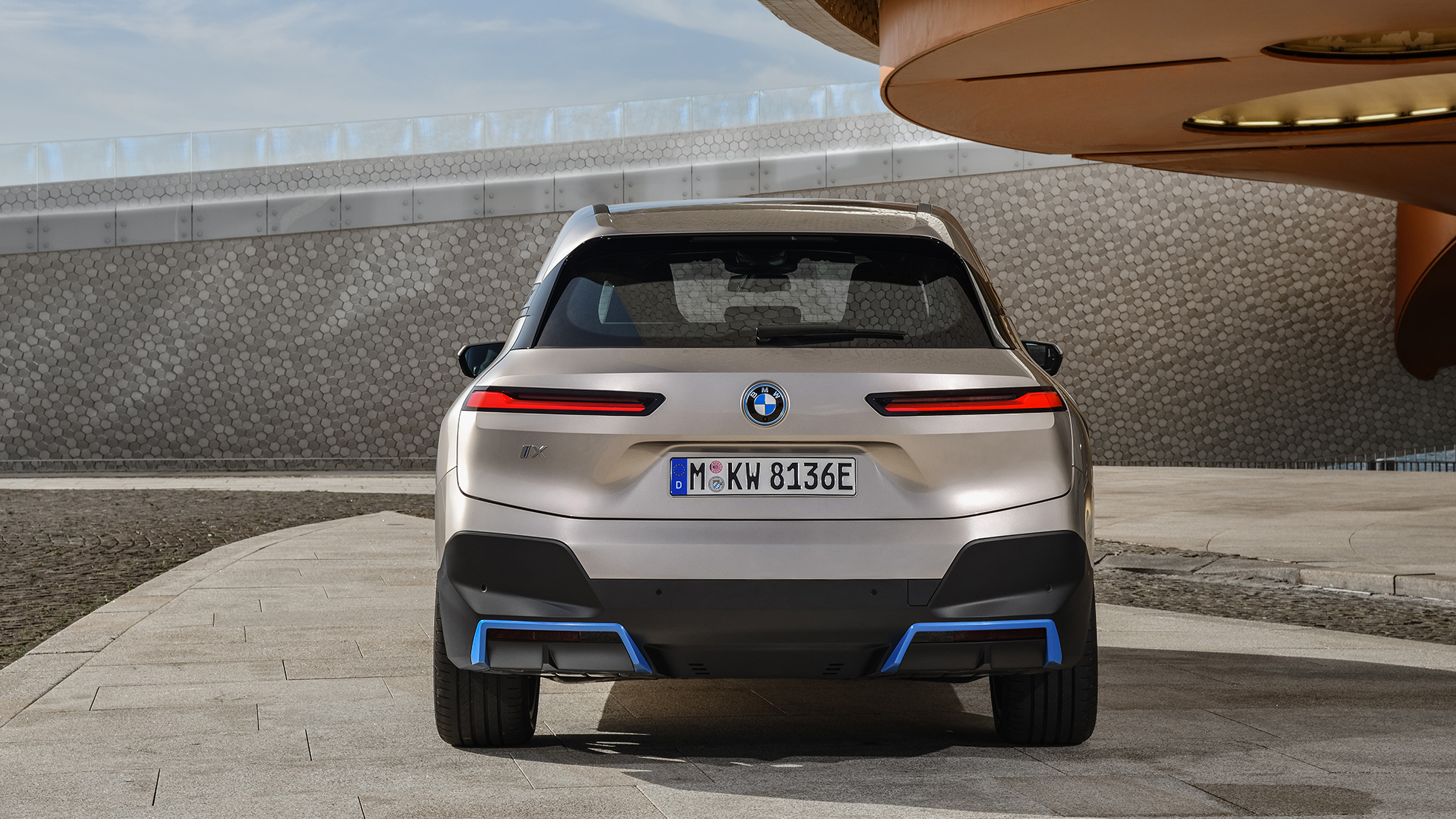 BMW iX, näkymä pysähtyneenä olevan auton perästä BMW iX Cashmere Silver i20, näkymä pysähtyneenä olevan auton perästä