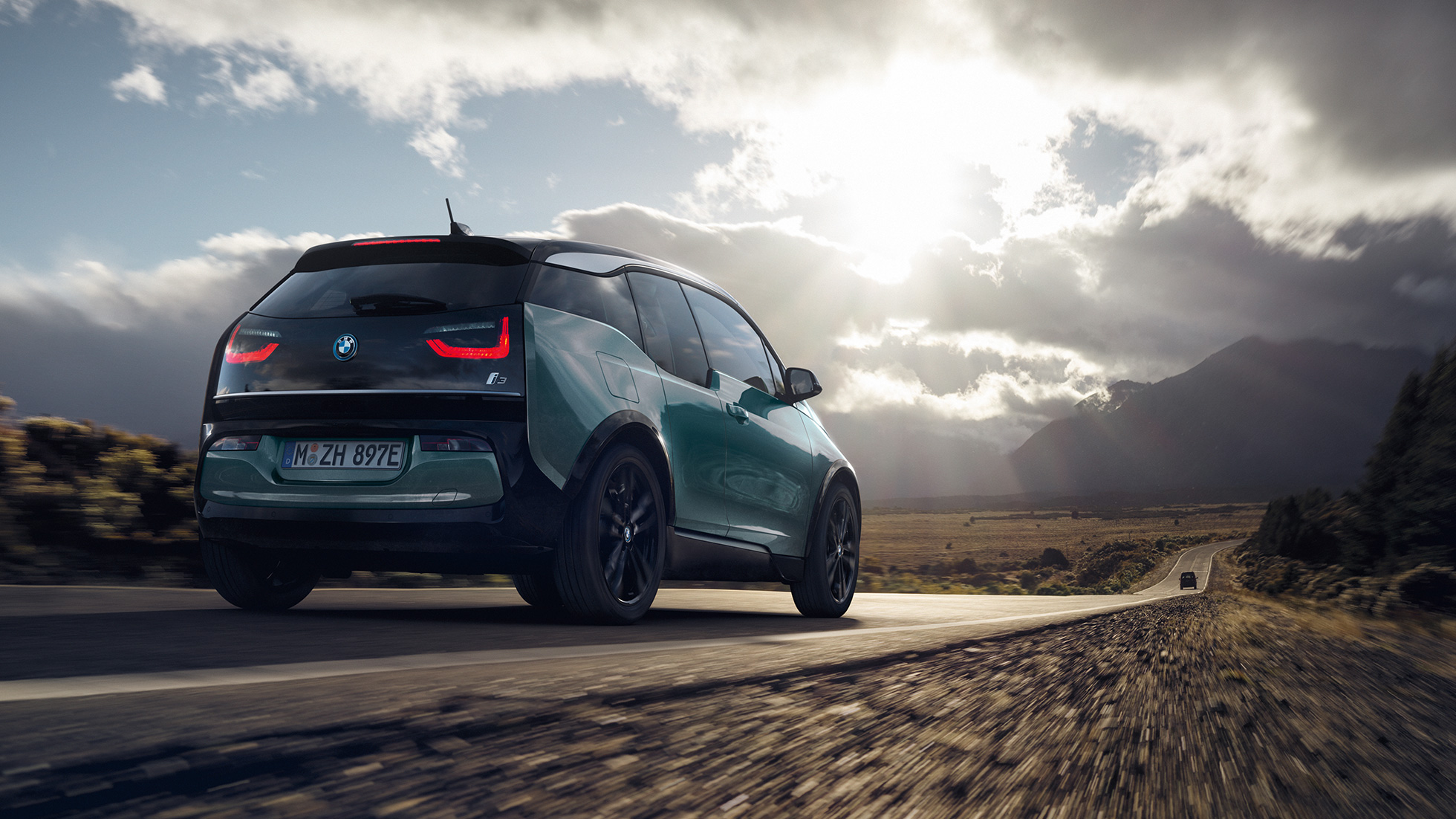 BMW i3 2018, kolmen neljäsosan näkymä auton perästä ajaen maantiellä BMW i3 I01 2018 Jucaro Beige, korostuksella Frozen Grey -metalliväri, kolmen neljäsosan näkymä auton perästä ajaen maantiellä