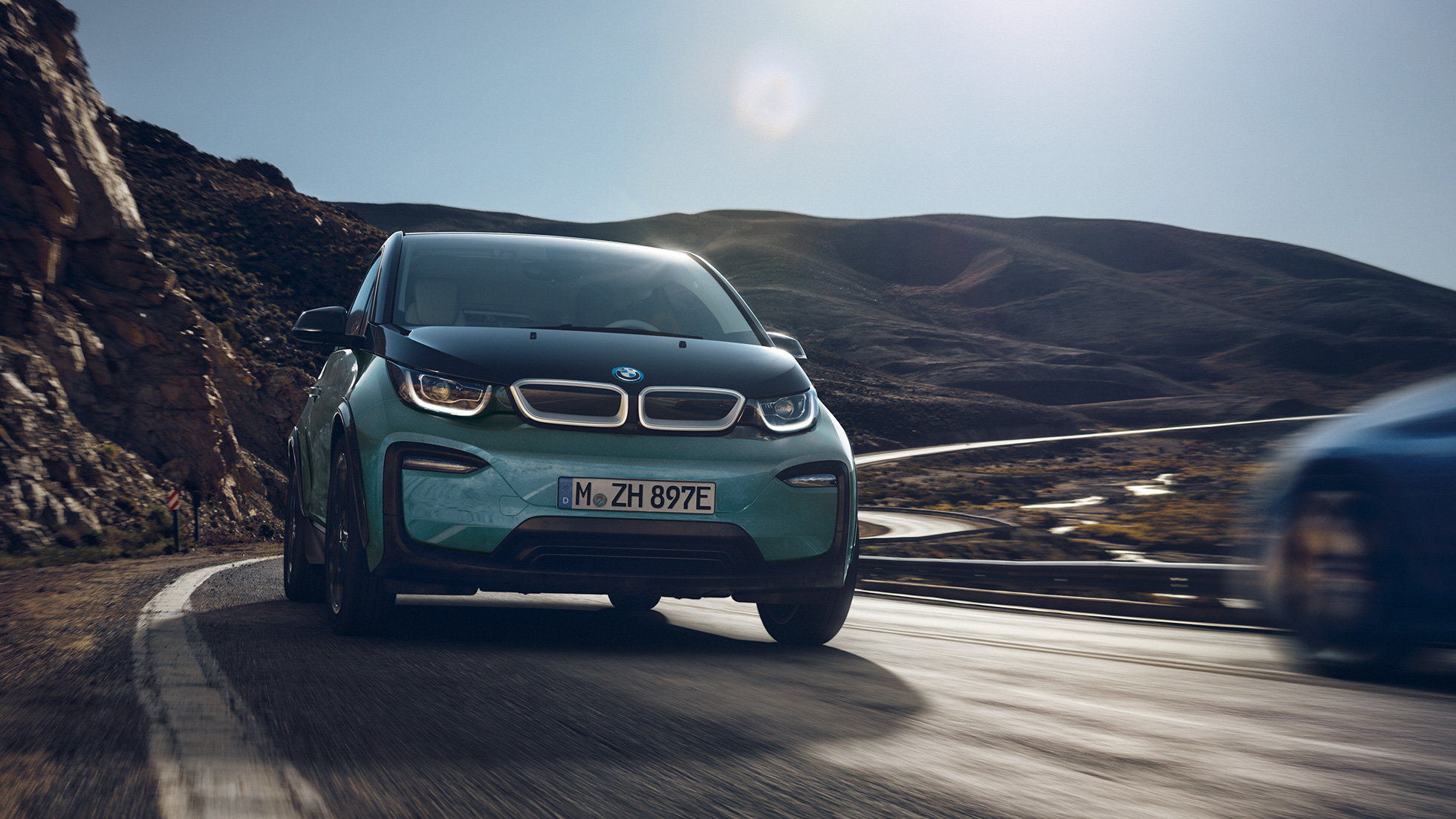 BMW i3 2018 sivunäkymä ajaen BMW i3 I01 2018 Jucaro Beige, korostuksella Frozen Grey -metalliväri, sivunäkymä ajaen kaupunkiympäristössä