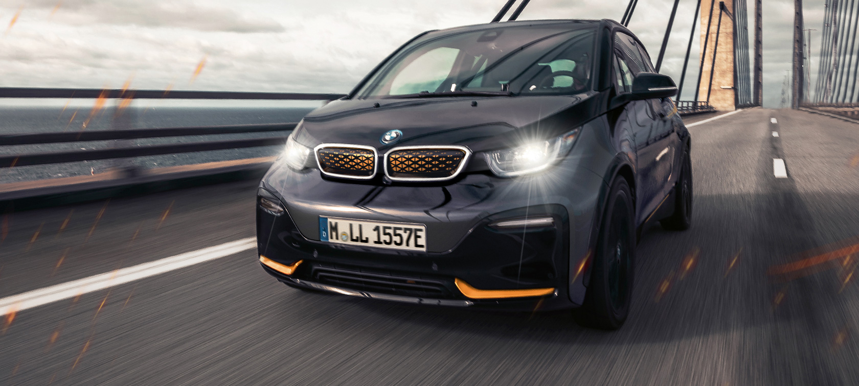 BMW i3 Unique Forever Edition I01 3/4-näkymä edestä BMW i3 Unique Forever Edition I01 Storm Bay, korostuksella Frozen E-Copper -metalliväri, 3/4-näkymä edestä ajaen maantiellä