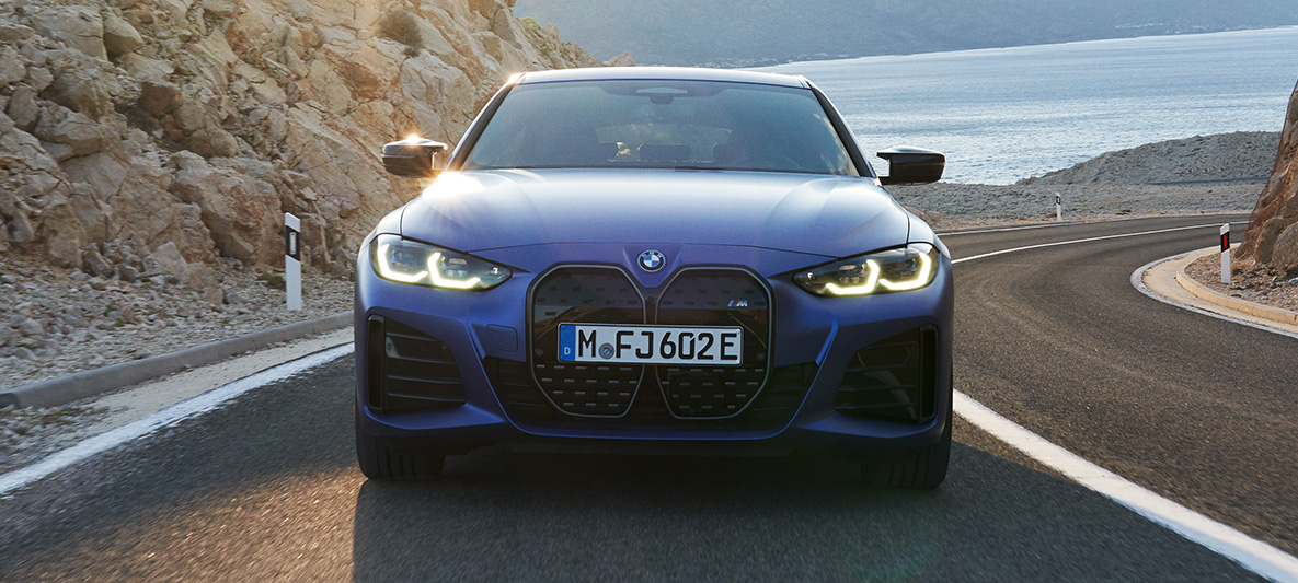 Näkymä edestä i4 eDrive40 G26 2021 ajava auto BMW i4 M50 G26 2021 metalliväri M Portimao Blue näkymä keulasta auto ajamassa kadulla