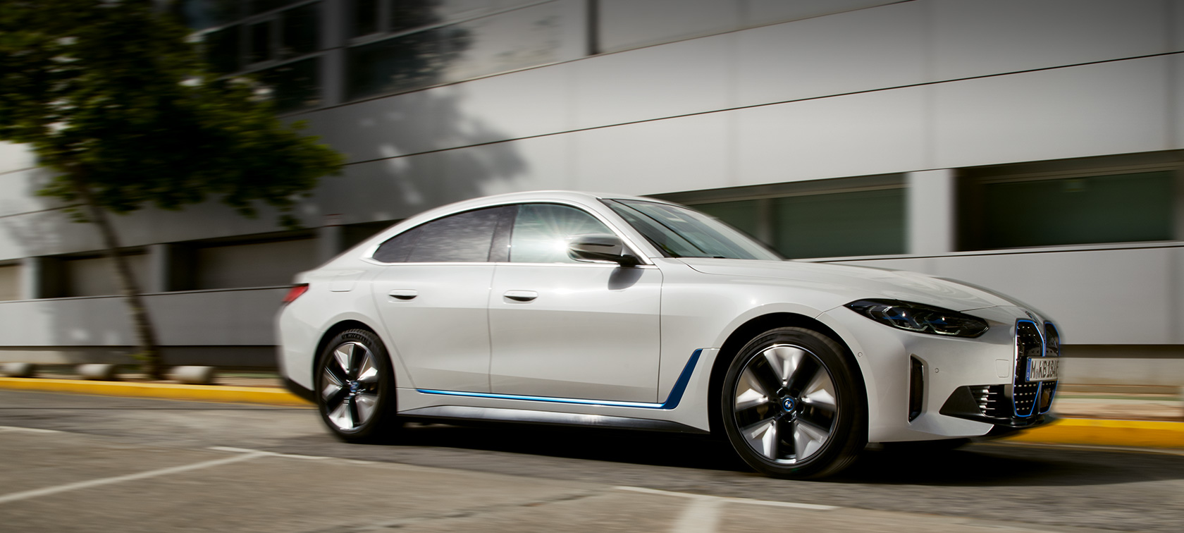 BMW i4 eDrive40 G26 2021 3/4-näkymä ajavasta autosta rakennuksen edessä BMW i4 eDrive40 G26 2021 3/4-näkymä ajavasta autosta rakennuksen edessä