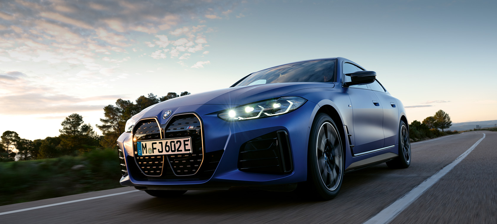 BMW i4 M50 G26 2021 sivunäkymä seisomassa kivisessä maastossa BMW i4 M50 G26 2021 BMW Individual -metalliväri Frozen Portimao Blue sivunäkymä seisomassa kivisessä maastossa